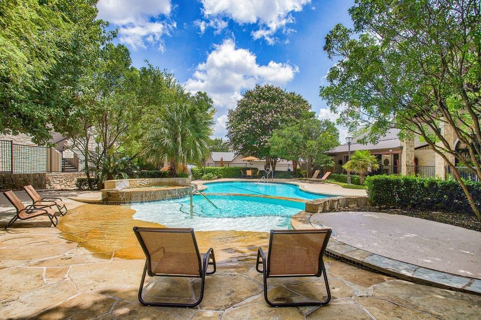 Mission oaks pool surrounded by trees and beach chairs