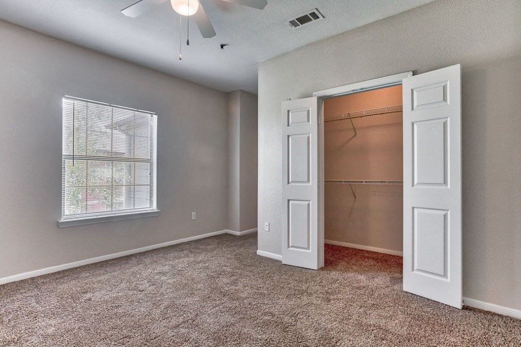 Bed room with white doors and closet and carpet floor