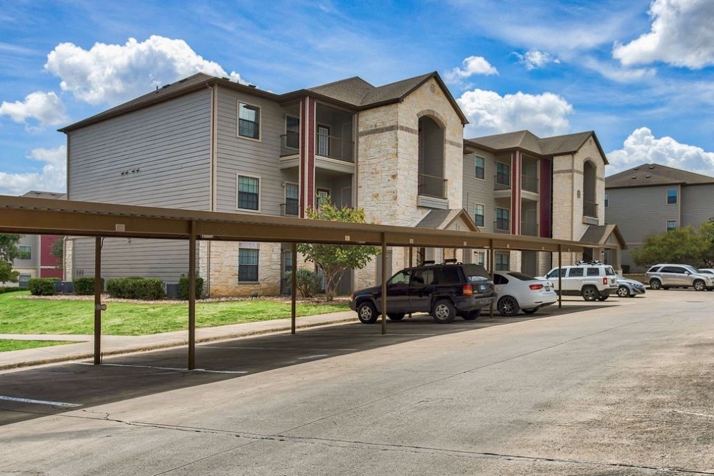 carports for parking in the shade with apartments in the background