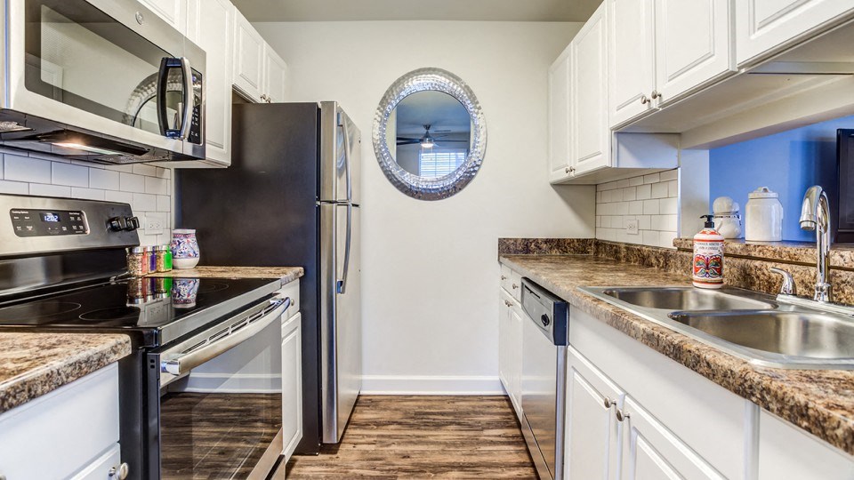 a modern kitchen with stainless steel appliances and granite counter tops