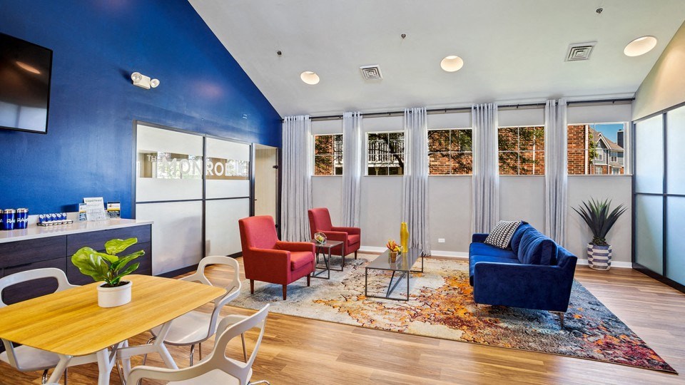 a living room with a blue wall and a table and chairs