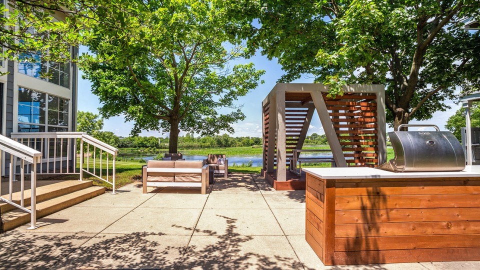 a patio with a hot tub and a deck with trees