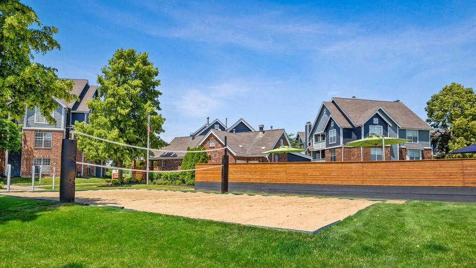 a volleyball court in front of a row of houses