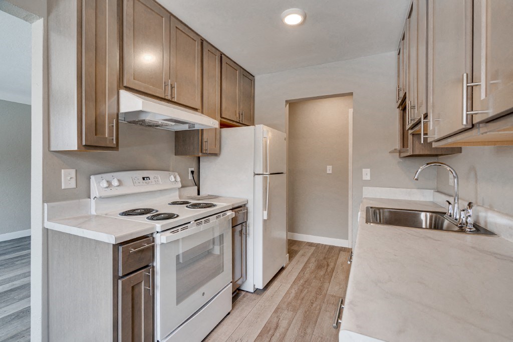 the kitchen of a home with white appliances and wooden cabinets