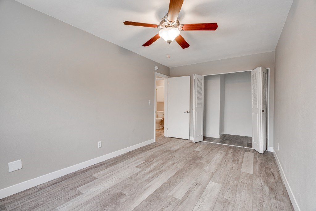 the living room of an empty house with a ceiling fan