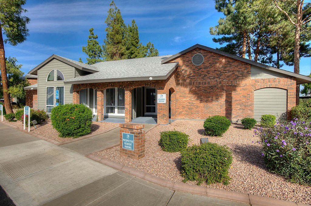 the front of a brick house with a driveway and landscaping