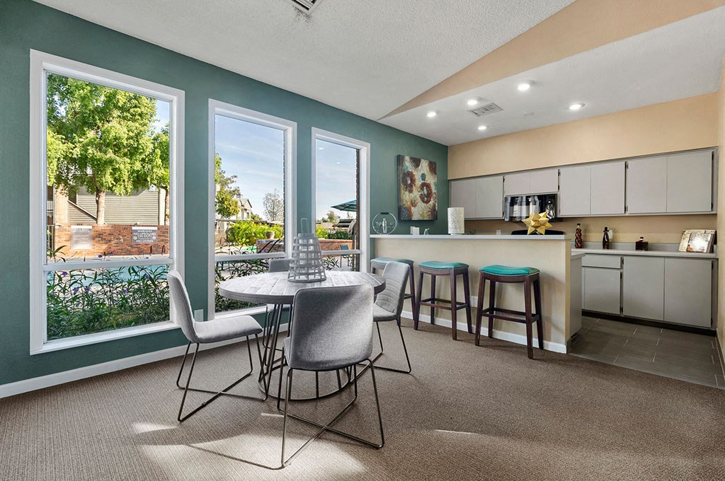 a dining room with a table and chairs next to a kitchen