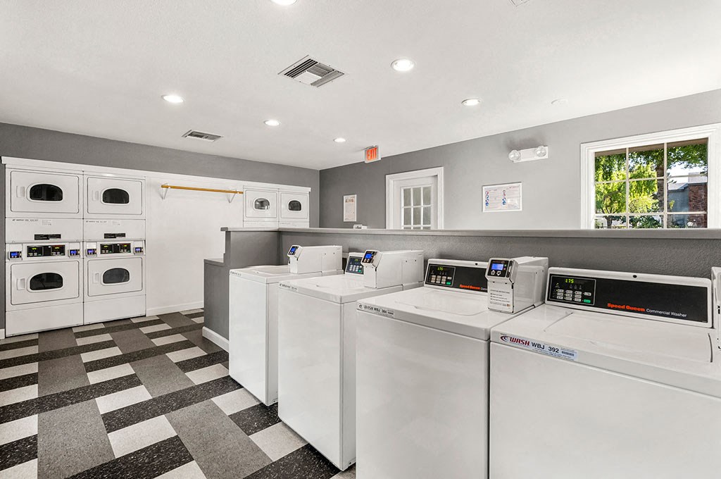 a laundry room with washers and dryers and a row of washing machines