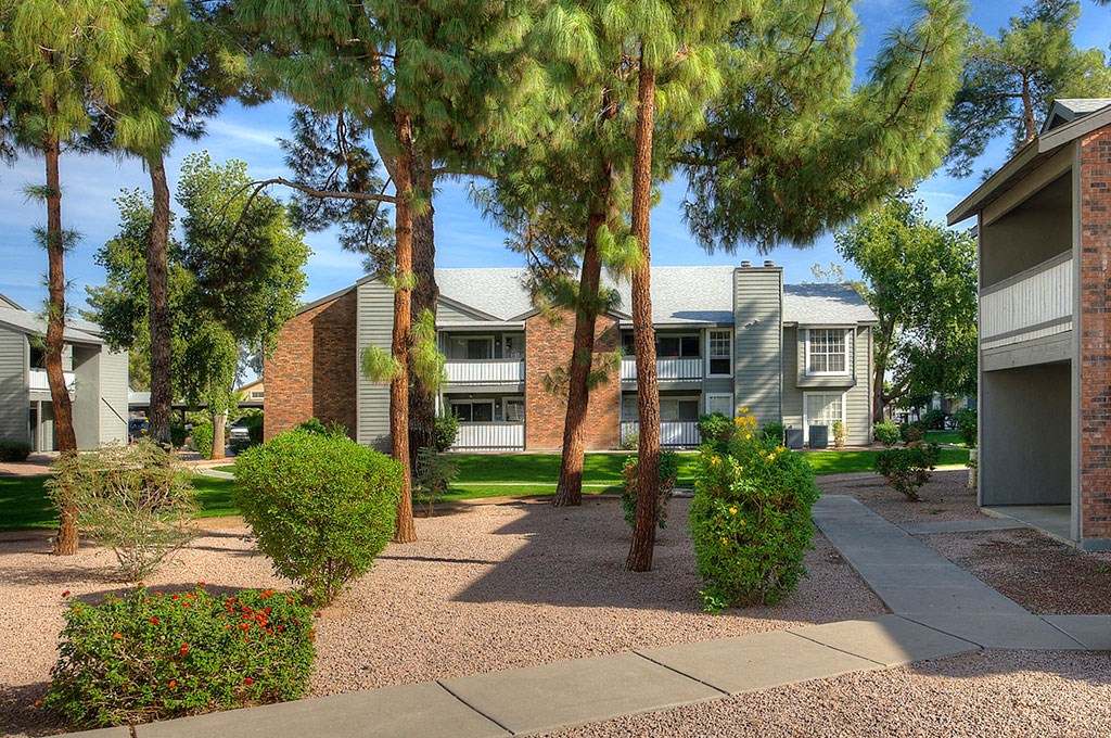 a courtyard with trees in front of apartment buildings