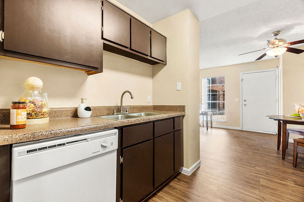 a kitchen with a sink and a ceiling fan