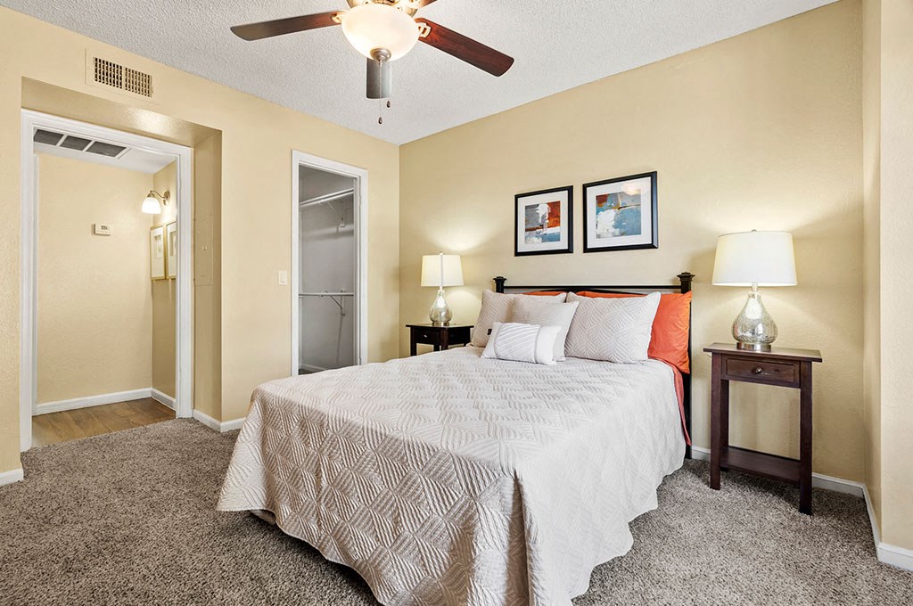 a bedroom with a bed and a ceiling fan