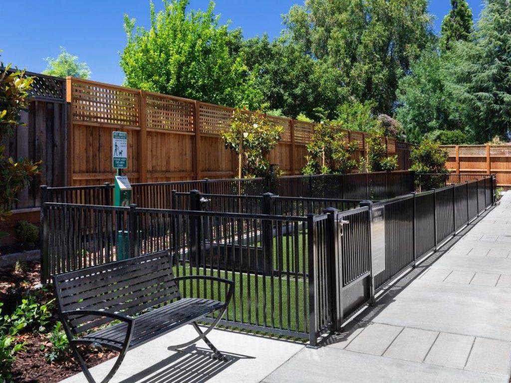 a park bench sitting in front of a fence