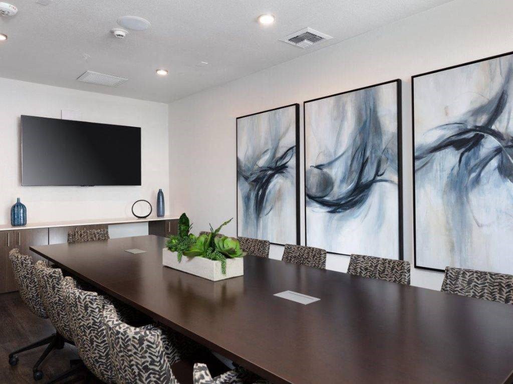 a conference room with a long table and a tv