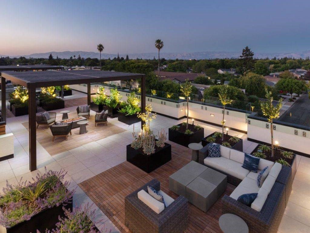 a roof top patio with furniture and a view of the city