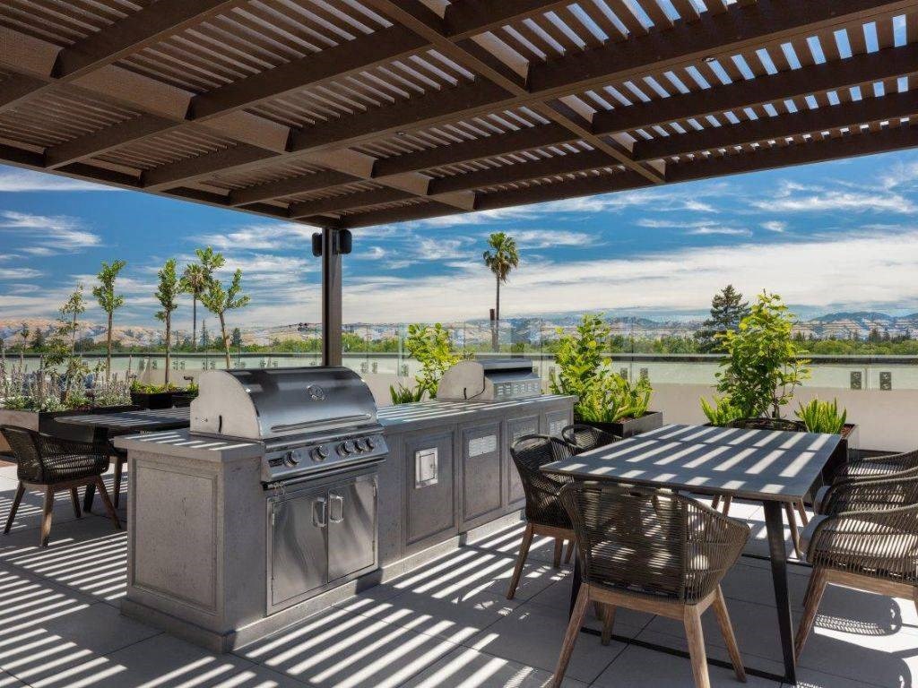 a patio with two grills and a table with chairs