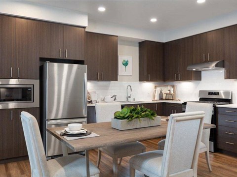 a kitchen with stainless steel appliances and a table with chairs