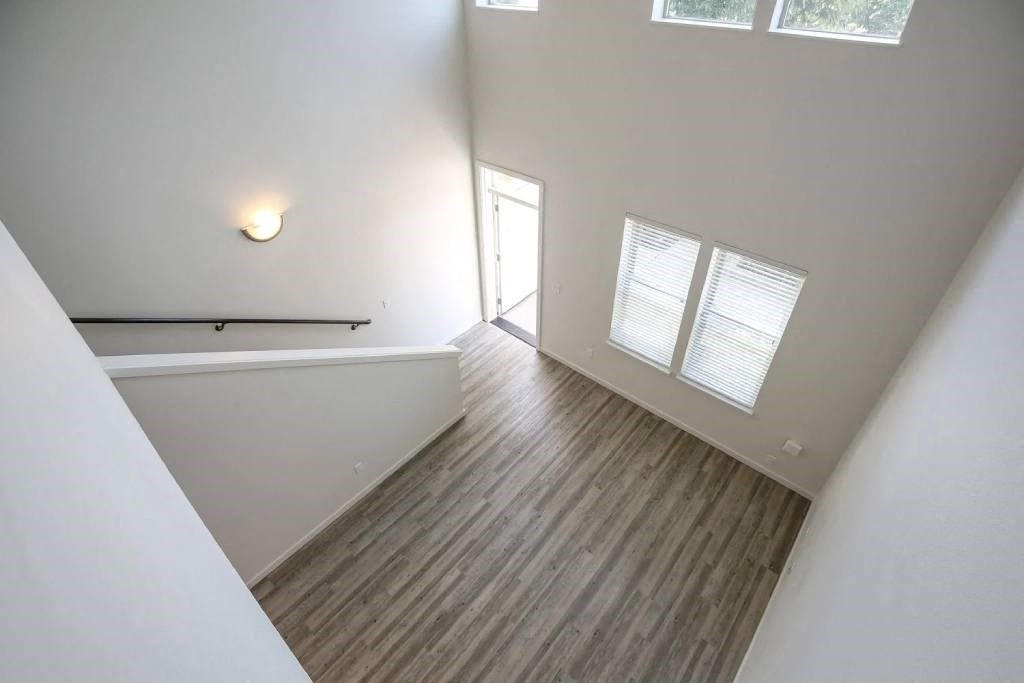 an empty living room with wood flooring and white walls