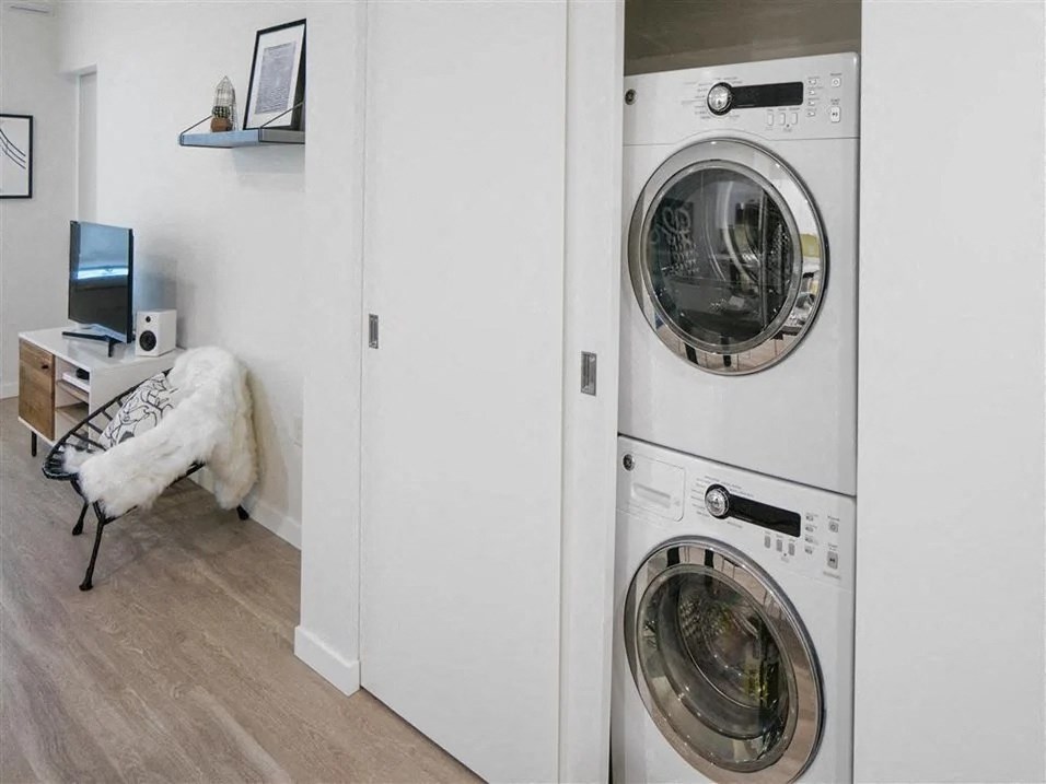 a washer and dryer in a room with a desk and computer