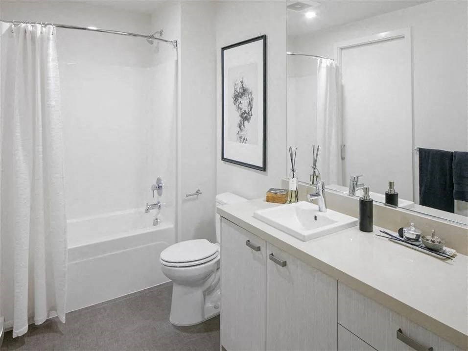 2-Bedroom Apartments In Beaverton, OR - Westline - Modern Bathroom With A Large Vanity Mirror, White Cabinets, And A Shower With Tub