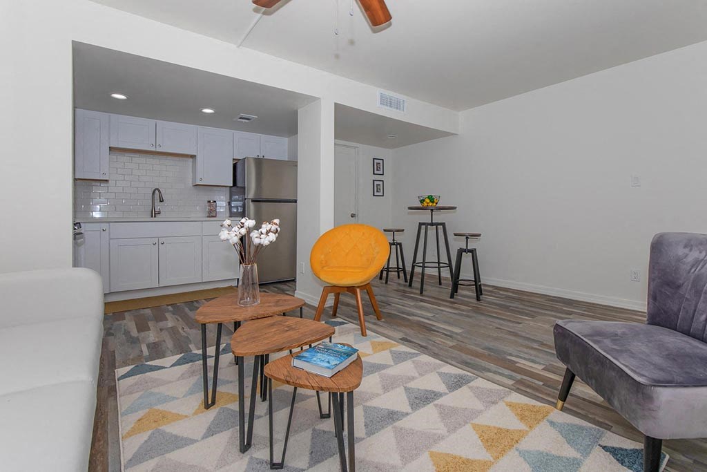 a living room with a kitchen in the background