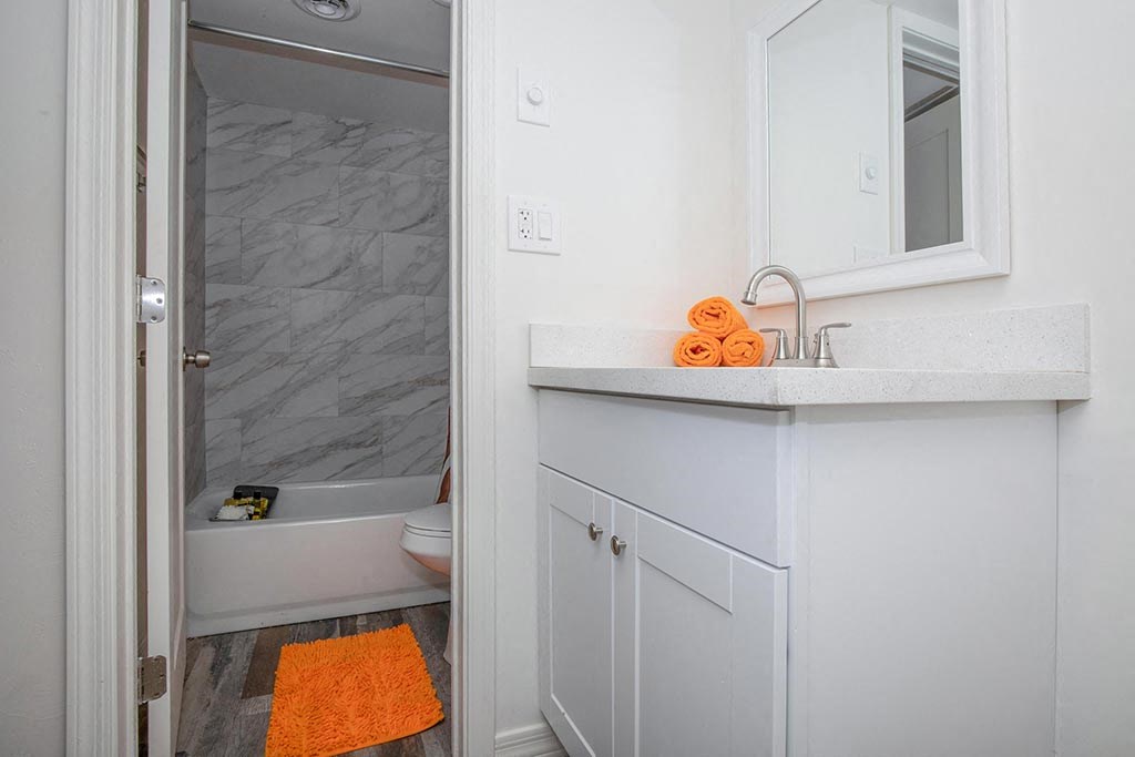 a bathroom with a sink and a tub and a mirror