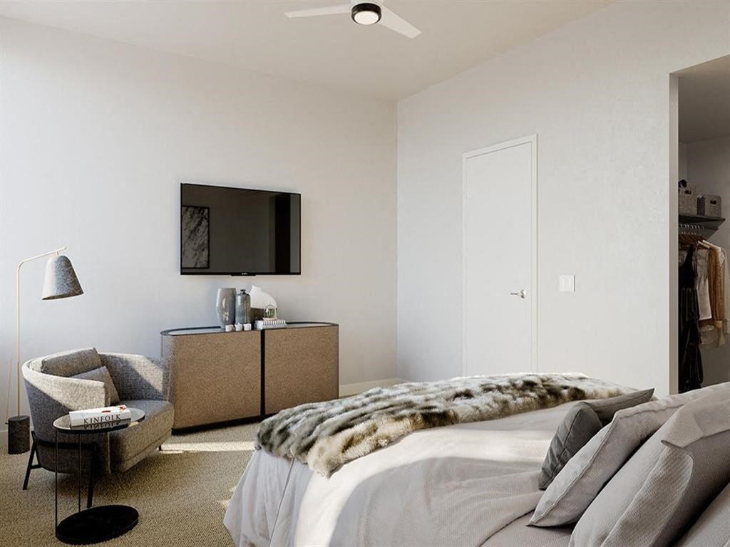 a bedroom with a bed and a television on the wall