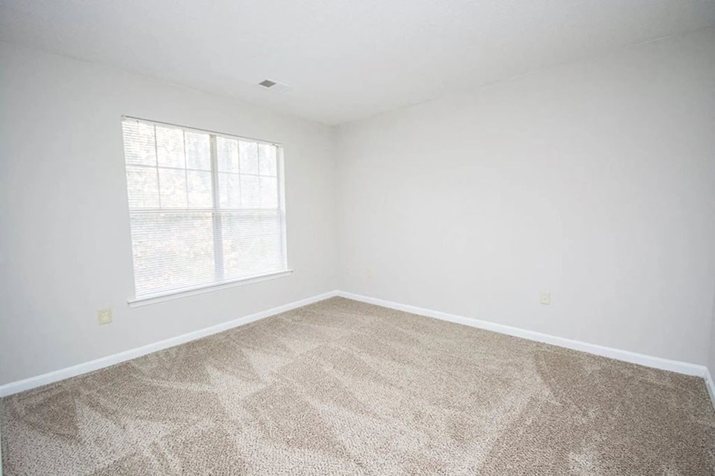 an empty room with carpet and a window