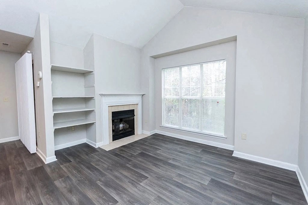 an empty living room with a fireplace and a window