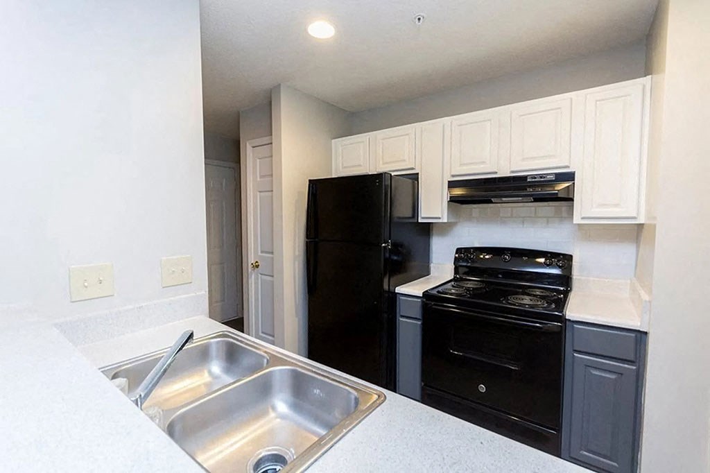 a kitchen with black appliances and a sink