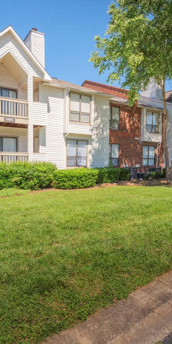 an apartment building with a lawn in front of it