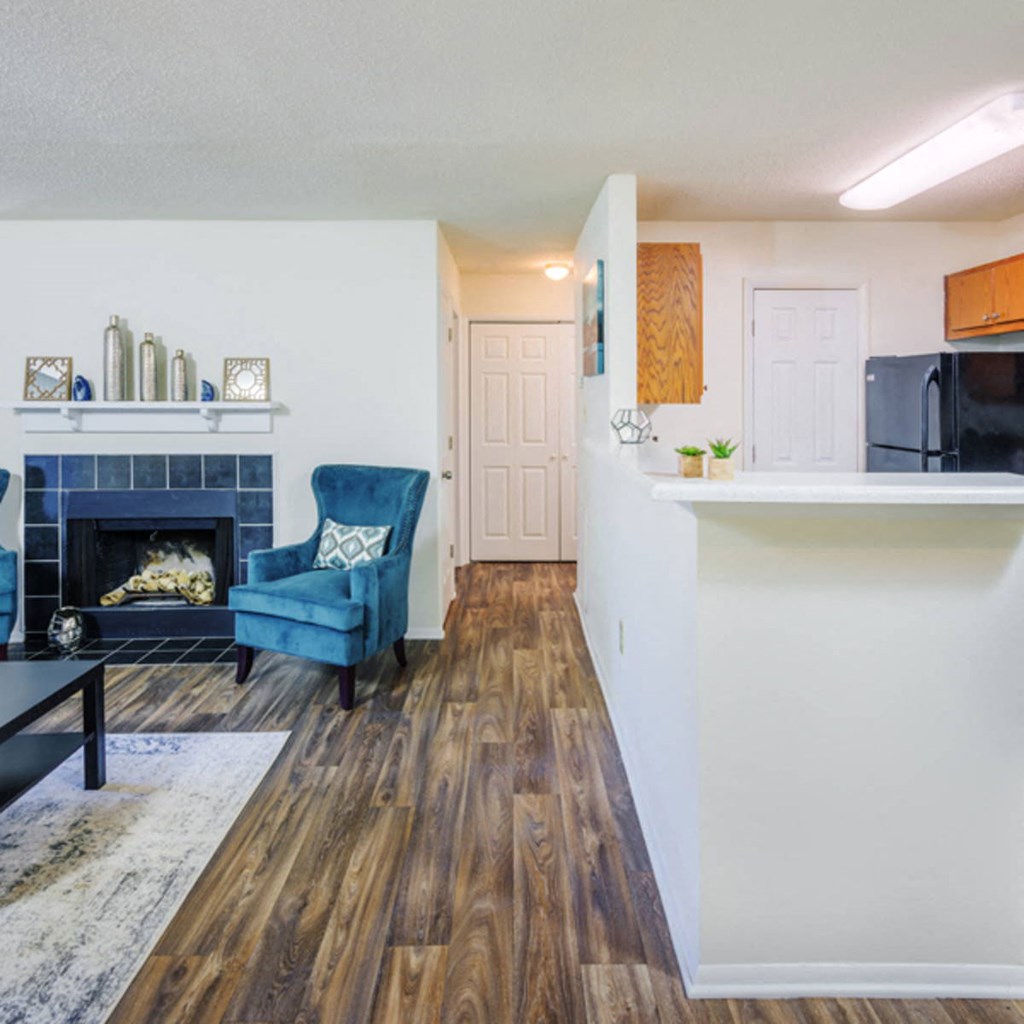 a living room with a fireplace and a kitchen