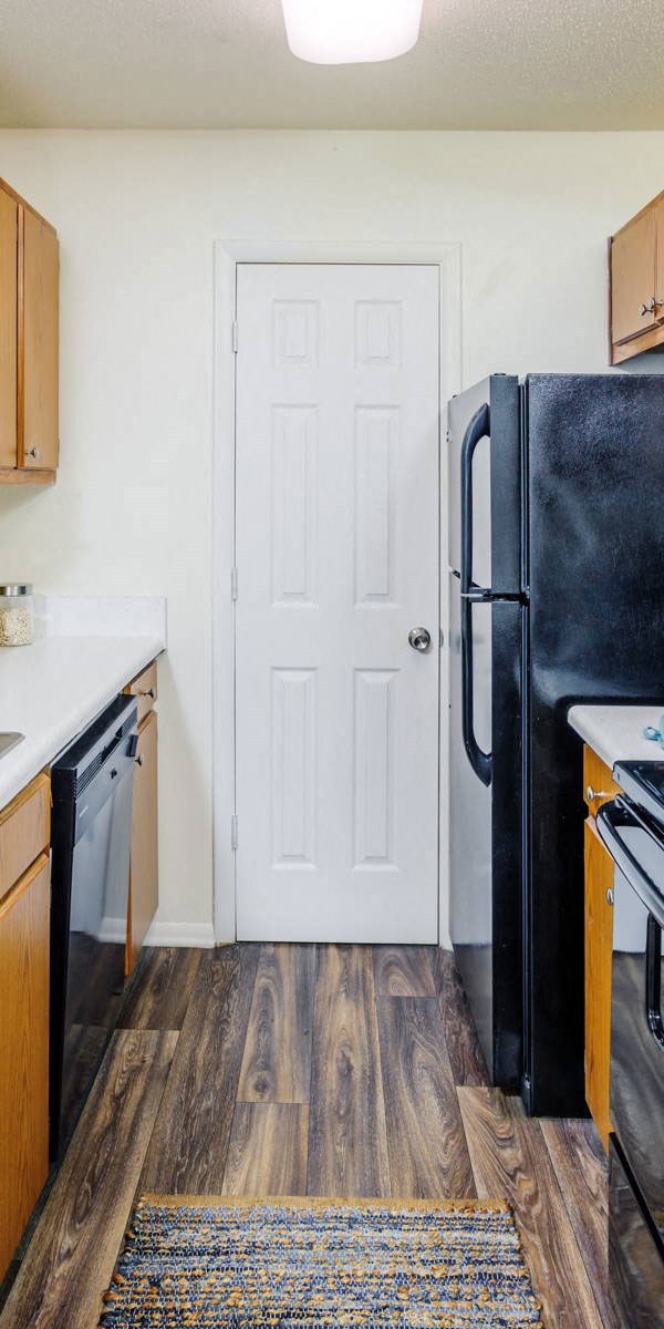 a kitchen with a black refrigerator and a door
