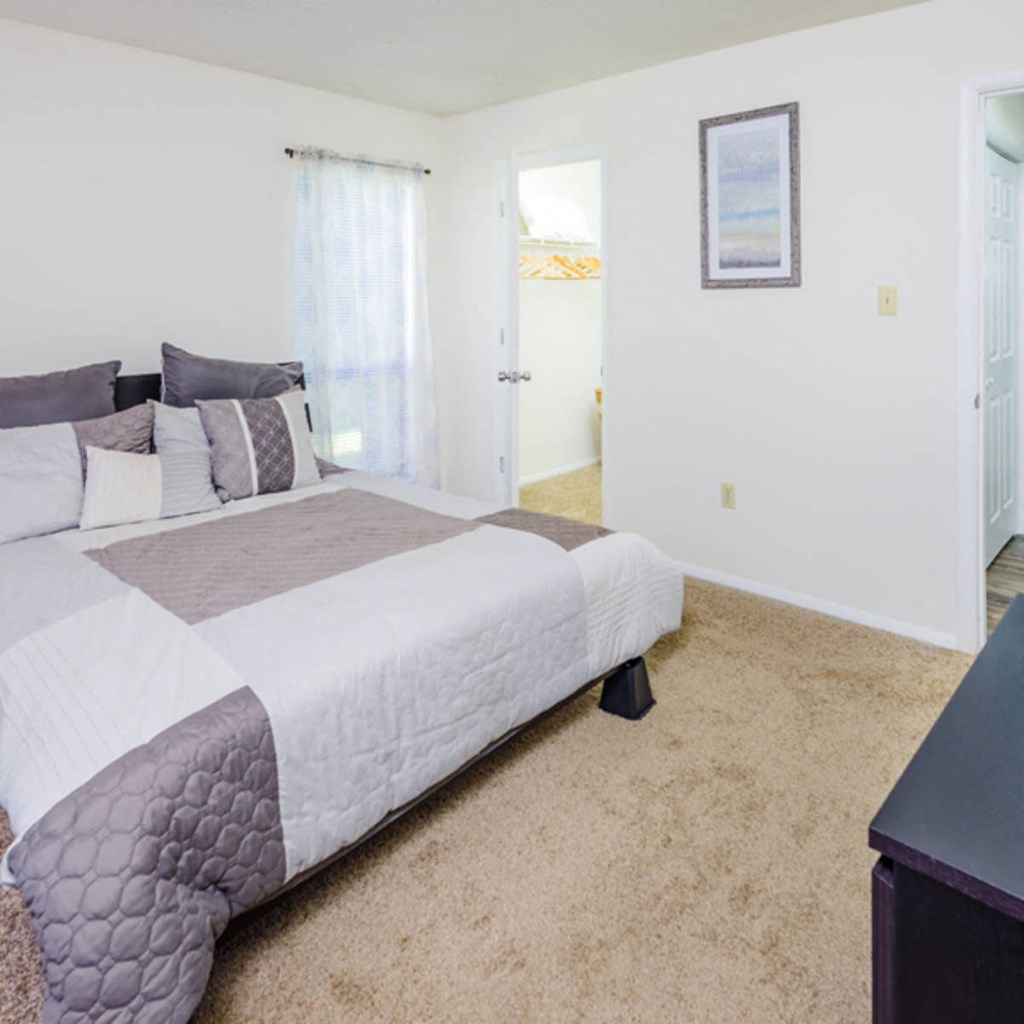 a bedroom with a bed and a door to a bathroom