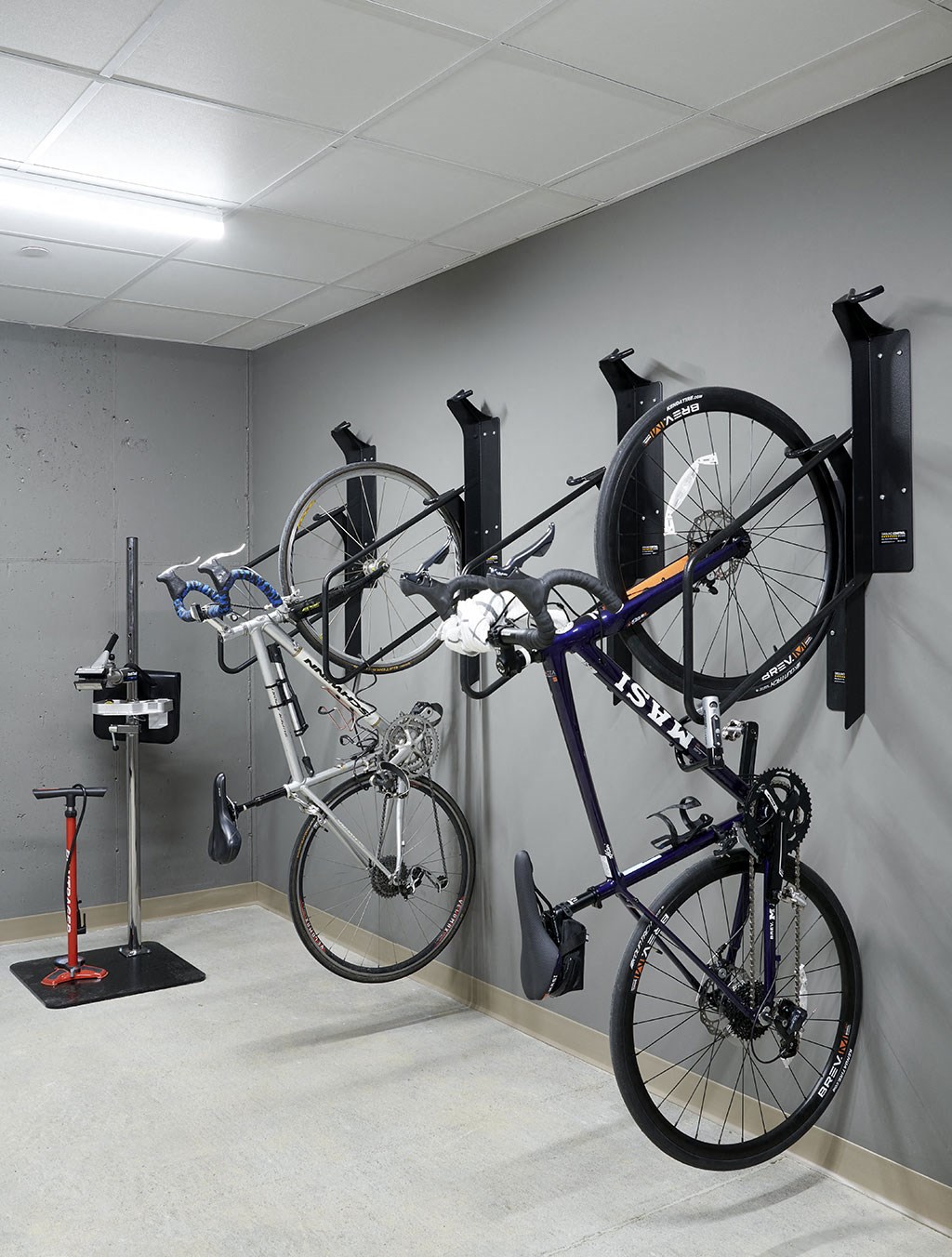 a bike storage room with two bikes hanging on a wall