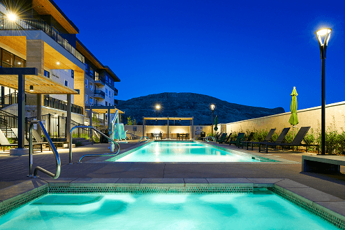a swimming pool at night with a mountain in the background