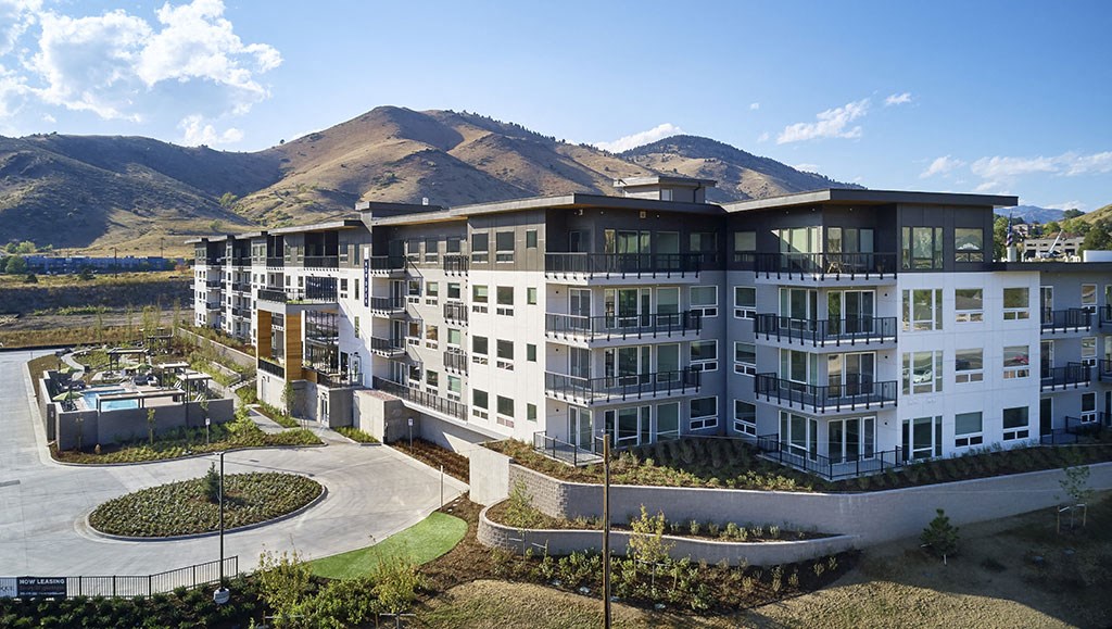 a large apartment building with mountains in the background