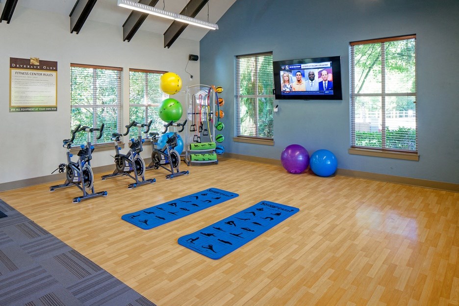 a gym with exercise balls and yoga mats and a television