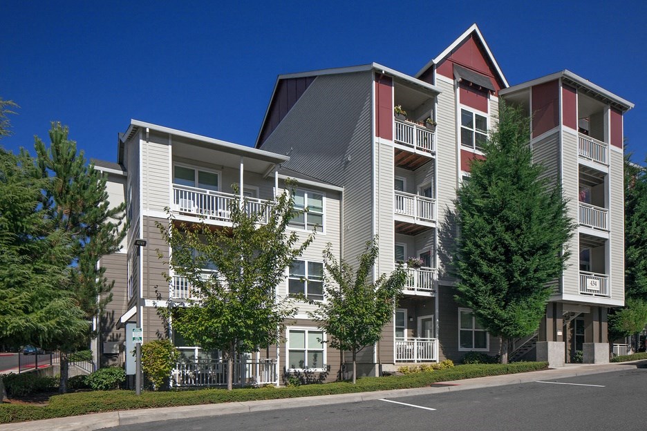 a street view of an apartment building with trees