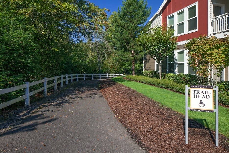 a trail head sign in front of a house