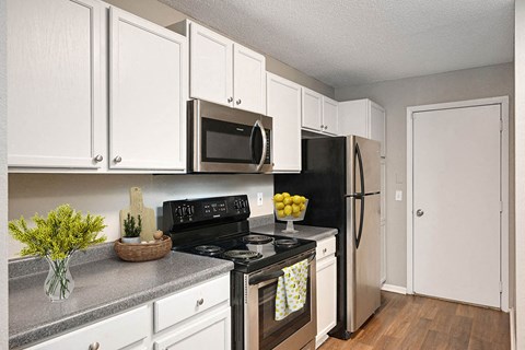 a kitchen with black appliances and white cabinets