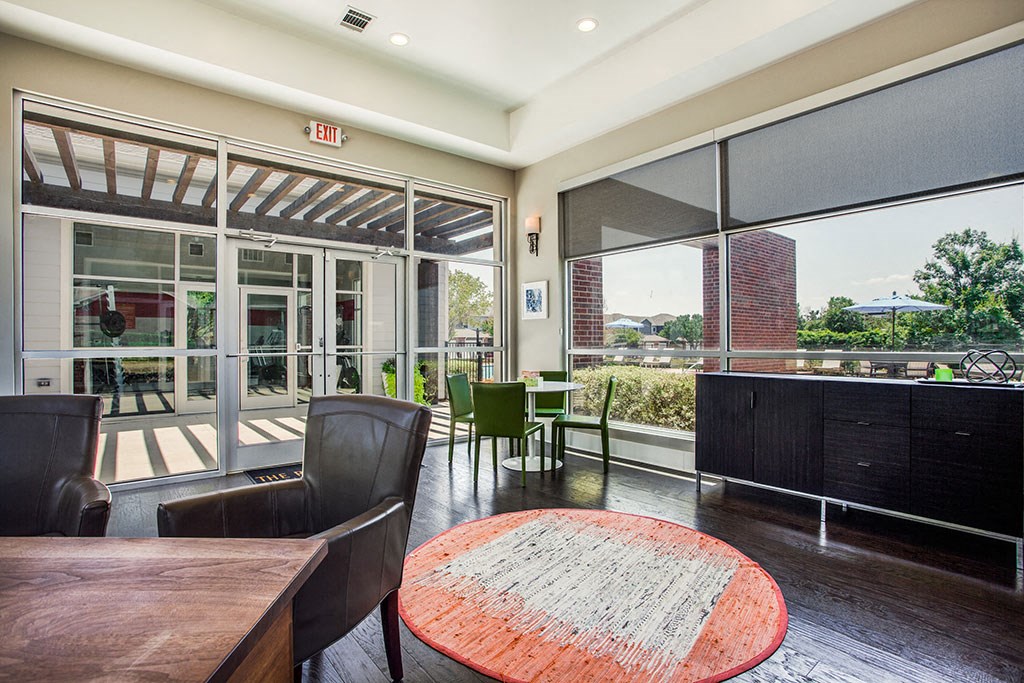 a room with a table and chairs and large windows