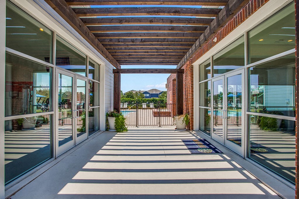 a covered patio with sliding glass doors and a view of the pool