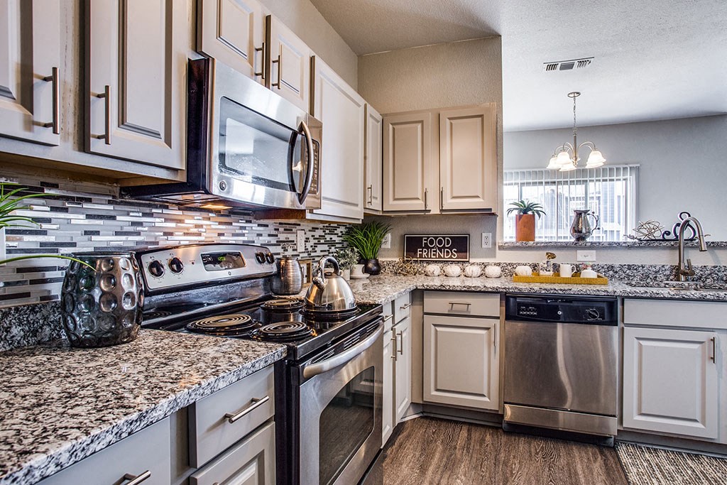 a kitchen with white cabinets and granite countertops