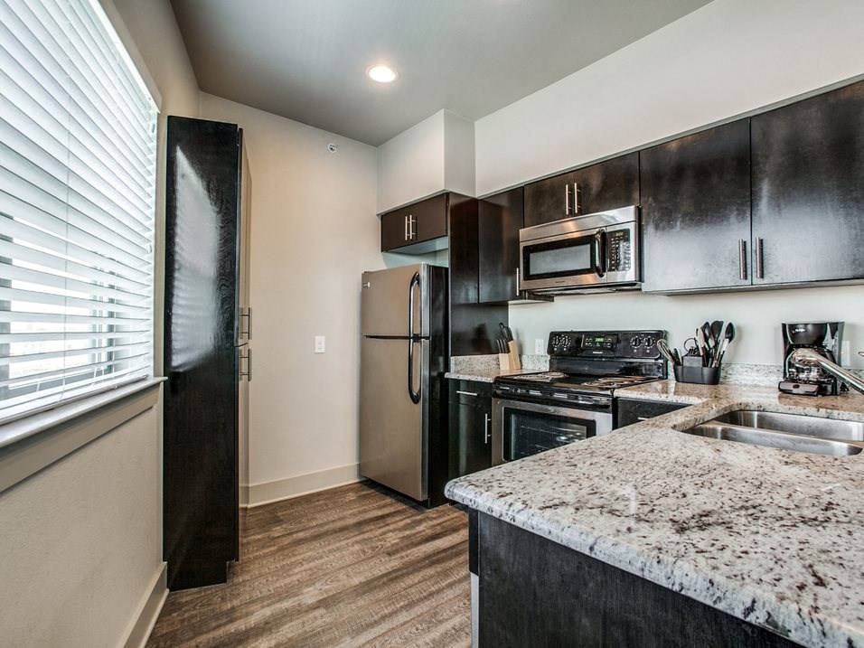 a kitchen with dark wood cabinets and granite countertops