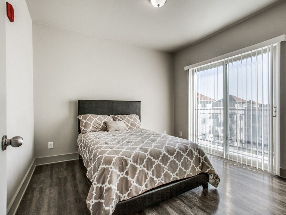 a bedroom with a large window and a large bed