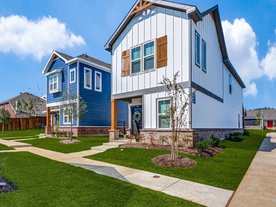a house with a white and blue siding and a blue and white house next to it