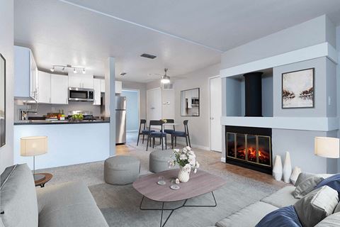 a living room with a fireplace and a kitchen in the background