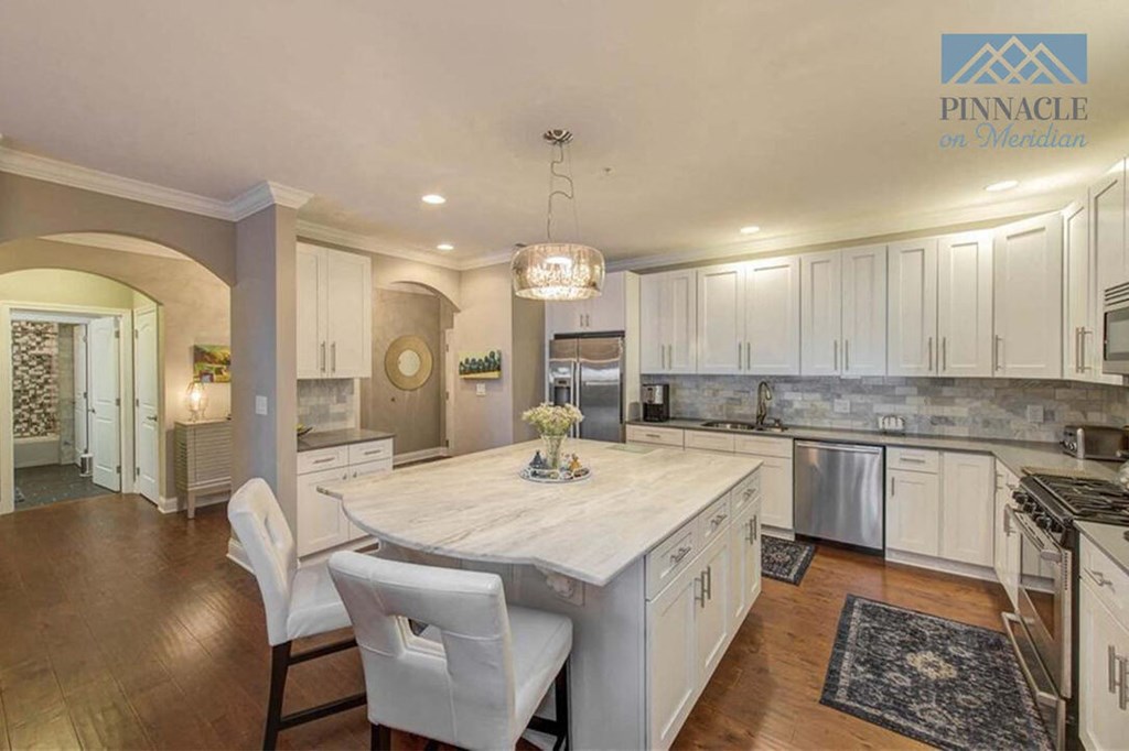 a kitchen with a large island and white cabinets