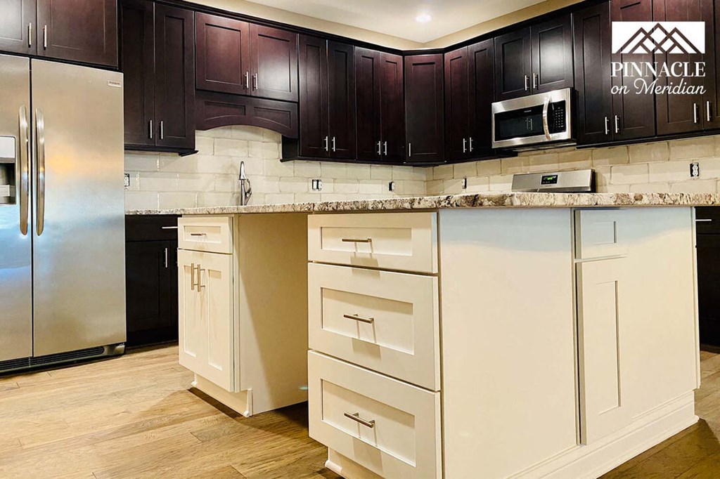 a kitchen with black cabinets and white drawers