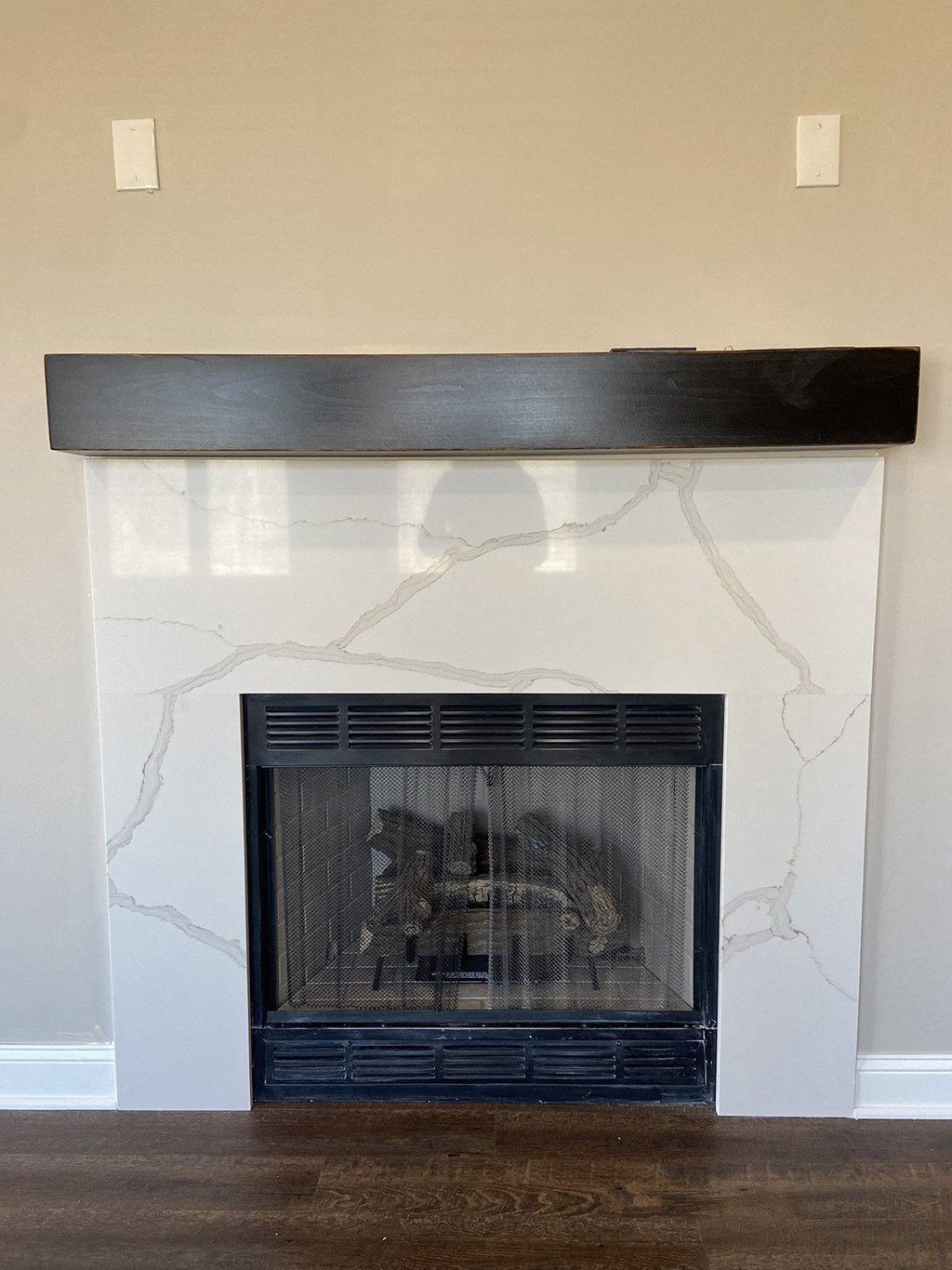 a wall with a fireplace and a mirror on it